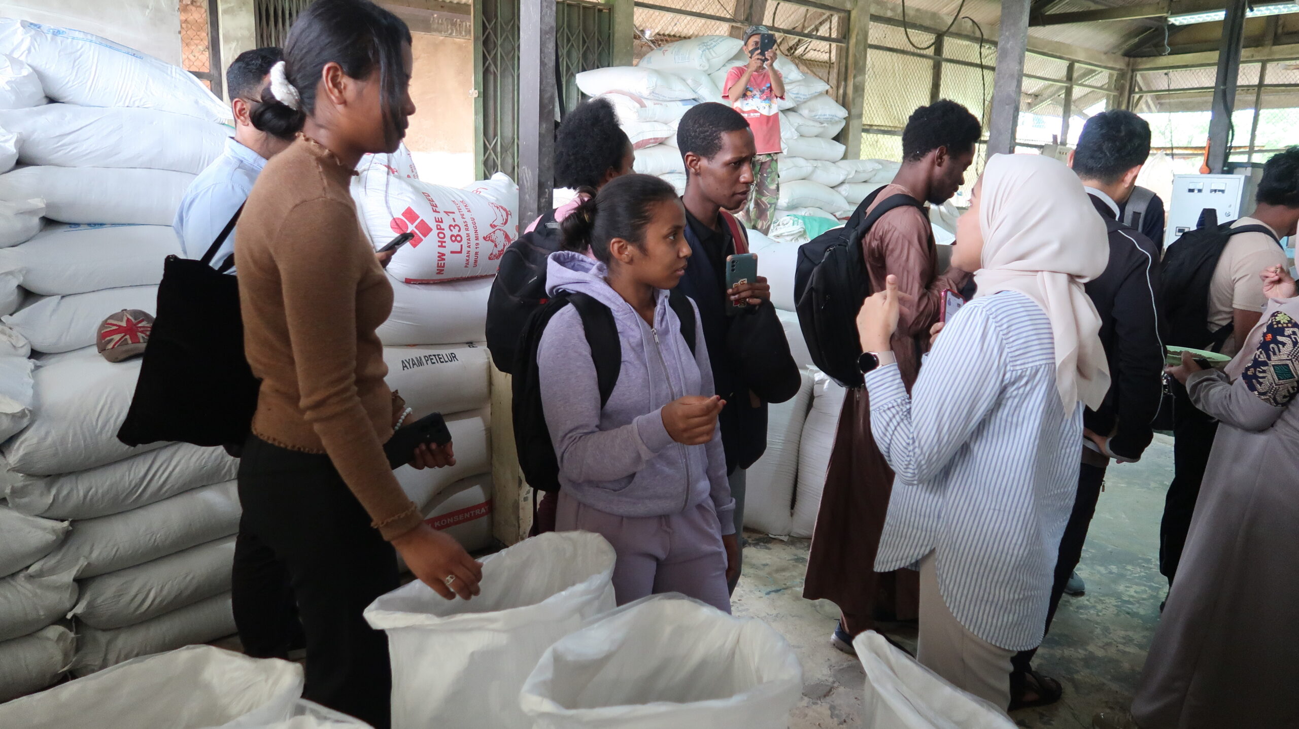 Nurul Fatimah (kanan depan) memberikan penjelasan tentang pembuatan pakan ikan kepada mahasiswa asal Afrika. ©Nurul Fatimah